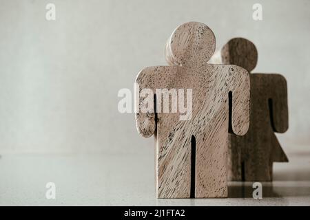 Figuren von Mann und Frau aus Holz auf neutralem Hintergrund Stockfoto