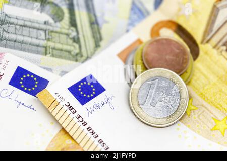 Eine Euro-Münze über einigen Banknoten unterschiedlicher Werte. Der Euro ist die europäische Währung. Finanzen, Wirtschaft und Unternehmen. Bargeld und Einsparungen Stockfoto