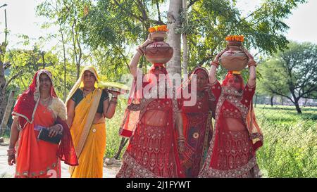 23 März 2022 Reengus, Rajasthan, Indien. Traditionelle indische Frauen, die Clay Kalash auf einem hinduistischen Fest am Kopf halten. Stockfoto