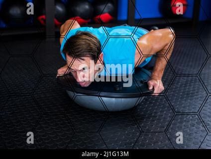 Sechseckige Formen Muster gegen kaukasischen fit Mann beim Training in der Turnhalle Stockfoto