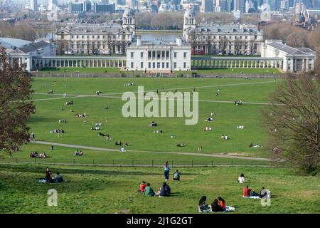 London, UK.  25 March 2022. UK Weather :  People enjoy the warm conditions in Greenwich Park as the temperature is forecast to rise to nearly 20C on a fine Spring afternoon.  On 27 March, the UK will move to British summer time, with clocks going forward one hour.  Credit: Stephen Chung / Alamy Live News Stockfoto