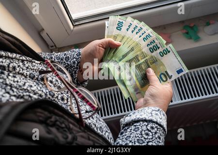 Nahaufnahme der Hände einer unbekannten kaukasischen älteren Frau, die 100-Euro-Banknoten hält und zählt, Geldvermögenversicherungszahlungen oder lebenslange Sparscheine Kopie sp Stockfoto