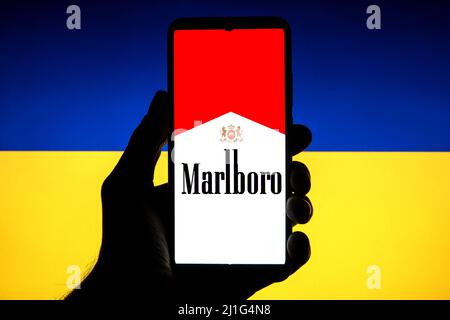 In dieser Abbildung ist ein Marlboro-Logo auf einem Smartphone mit einer ukrainischen Flagge im Hintergrund zu sehen. Stockfoto