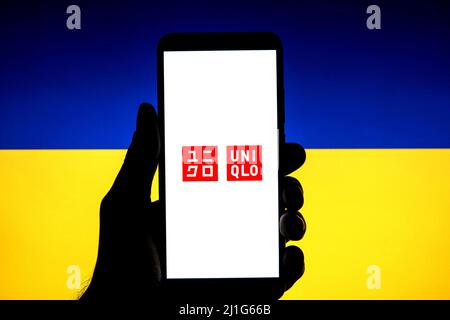 Spanien. 23. März 2022. In dieser Abbildung ist ein Uniqlo-Logo auf einem Smartphone mit einer ukrainischen Flagge im Hintergrund zu sehen. (Bild: © Thiago Prudencio/SOPA Images via ZUMA Press Wire) Stockfoto