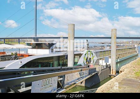 Düsseldorf, Deutschland - März 23. 2022: Blick auf Pier mit großem rhein-Flusskreuzfahrtschiff, Brückenhintergrund Stockfoto