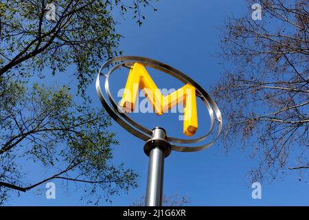 Metro-Schild in Paris, Frankreich auf blauem Himmel mit Bäumen Stockfoto
