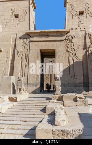 Schritte, die zum Eingangstor des ersten Pylons des Tempels der Isis bei Philae führen, der von zwei Granitlöwen bewacht wird Stockfoto