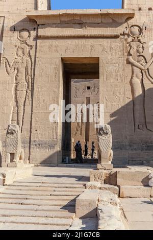 Schritte, die zum Eingangstor des ersten Pylons des Tempels der Isis bei Philae führen, der von zwei Granitlöwen bewacht wird Stockfoto