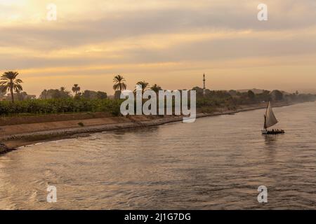 Felucca segelt auf dem Nil, mit Minarett im Hintergrund Stockfoto