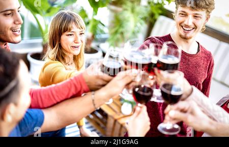 Trendige Freunde trinken und toasten Rotwein auf der Dachparty - Junge Leute haben Spaß zusammen in Restaurant Weinkellerei Bar auf Happy Hour Stockfoto