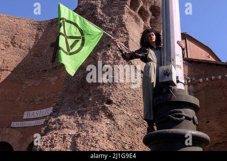 Rom, Italien. 25. März 2022. Ein Protestler hält eine Flagge der Umweltbewegung Extinction Rebellion. Klimaaktivisten veranstalteten eine von Fridays for Future organisierte Demonstration im Rahmen des Global Climate Strike, in der Maßnahmen gegen den Klimawandel gefordert wurden. Kredit: SOPA Images Limited/Alamy Live Nachrichten Stockfoto