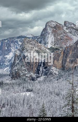 Vertikale Sicht auf das Yosemite Valley mit Cathedral Spires und Bridalveil fällt im Winter nach einem Schneesturm Stockfoto