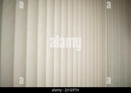 Weiße Jalousien. Tageslicht durch Jalousien. Sonnenschutz im Zimmer. Details zur Innenausstattung. Stockfoto