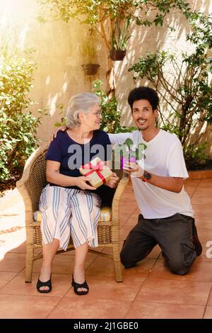 Glückliche interracial Familie. Kaukasische Mutter und ihr schwarzer Sohn im Hausgarten. Stockfoto