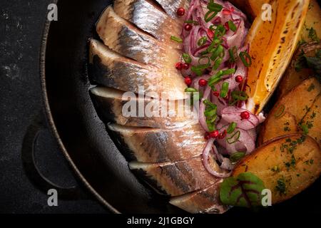 Eingelegter Hering mit gebackenen Kartoffeln und Zwiebeln Stockfoto