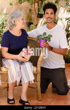 Glückliche interracial Familie. Kaukasische Mutter und ihr schwarzer Sohn im Hausgarten. Stockfoto