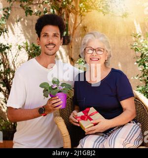 Glückliche interracial Familie. Kaukasische Mutter und ihr schwarzer Sohn im Hausgarten. Stockfoto