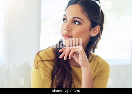 Ich verbringe einige Zeit allein mit meinen Gedanken. Aufnahme einer schönen jungen Frau, die sich zu Hause entspannt. Stockfoto