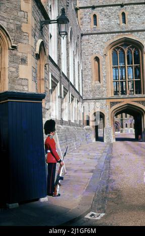 1960s, historisch, Grenadier Wache vor seinem Wachkasten in der historischen königlichen Residenz von Windsor Castle, Berkshire, England, Großbritannien. Ein Wachmann wird zwei Stunden lang im Wachdienst sein. Eine Reihe von verschiedenen Infanterieregimenten stellen die Wachen auf der Burg, sowie zwei Regimenter der Kavallerie im Haushalt zur Verfügung. Stockfoto