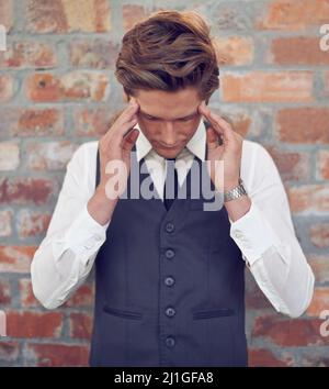 Man muss sich entspannen. Aufnahme eines gut gekleideten jungen Mannes, der gestresst aussieht. Stockfoto