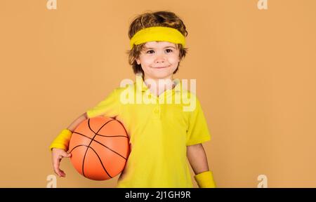 Kind Junge in Sportbekleidung mit Basketball. Kleiner Basketballspieler. Sportausrüstung. Sportspiel Stockfoto