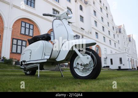 Italienische Innocenti Lambretta SX150 Motorroller, fotografiert am Worthing Meer, der Pier, der Dom, Fischerboot Stockfoto