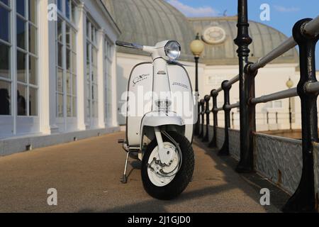 Italienische Innocenti Lambretta SX150 Motorroller, fotografiert am Worthing Meer, der Pier, der Dom, Fischerboot Stockfoto