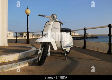 Italienische Innocenti Lambretta SX150 Motorroller, fotografiert am Worthing Meer, der Pier, der Dom, Fischerboot Stockfoto