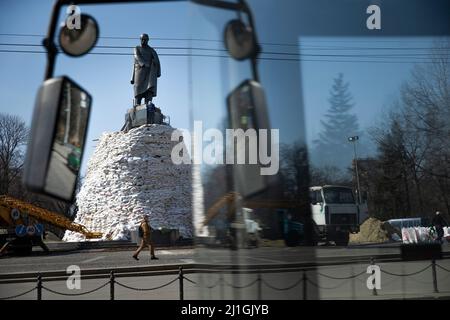 Charkiw, Ukraine. 25. März 2022. Ein Mann geht am 25. März 2022 in der Nähe des Denkmals des Dichters Taras Schewtschenko in Charkiw, Ukraine. Arbeiter stellten Sandsäcke um das Statut, um es vor russischem Beschuss zu schützen. Kredit: ZUMA Press, Inc./Alamy Live Nachrichten Stockfoto