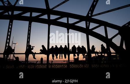 München, Deutschland. 25. März 2022. Zahlreiche Menschen genießen das schöne Wetter auf der Hackerbrücke und beobachten den Sonnenuntergang. Quelle: Sven Hoppe/dpa/Alamy Live News Stockfoto
