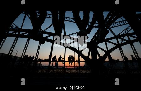 München, Deutschland. 25. März 2022. Zahlreiche Menschen genießen das schöne Wetter auf der Hackerbrücke und beobachten den Sonnenuntergang. Quelle: Sven Hoppe/dpa/Alamy Live News Stockfoto
