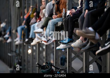 München, Deutschland. 25. März 2022. Zahlreiche Menschen genießen das schöne Wetter auf der Hackerbrücke und beobachten den Sonnenuntergang. Quelle: Sven Hoppe/dpa/Alamy Live News Stockfoto