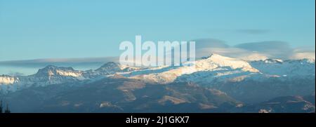 Spektakuläre linsenförmige Wolken über den Gipfeln der Sierra Nevada (Spanien) bei Sonnenuntergang im Winter Stockfoto