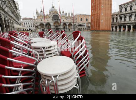 Stühle und Tische einer Bar im Freien auf dem Markusplatz in Venedig in Italien während der Überschwemmungen mit hohem Wasser aufgrund des Klimawandels Stockfoto