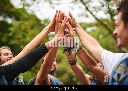 Lassen Sie uns das tun. Eine kurze Aufnahme einer Gruppe junger Freunde mit hohem Fiving während einer Wildwasser-Rafting-Tour. Stockfoto