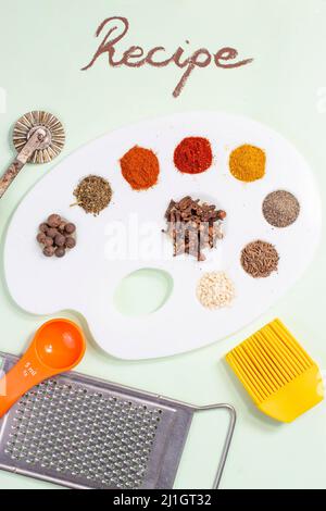 Rezept neben der Palette eines Malers mit Gewürzen und Gewürzen Stockfoto