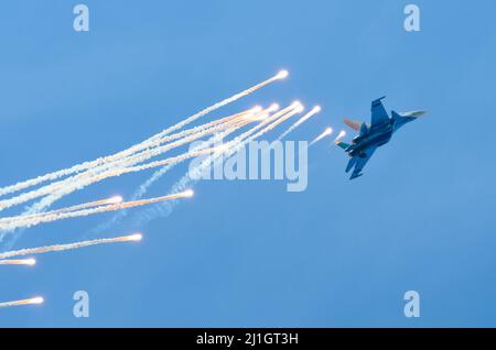 Flugzeugjäger fliegt und schießt Heißluftgewehre in den blauen Himmel Stockfoto