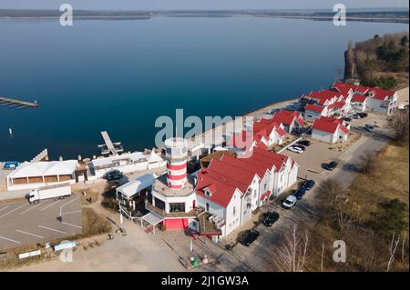Elsterheide, Deutschland. 25. März 2022. Das Lighthouse Hotel am Geierswalder See. Am 2. April 2022 feiert der Tourismusverband Lausitzer Seenland sein 10.-jähriges Bestehen. (Luftaufnahme mit einer Drohne) Quelle: Sebastian Kahnert/dpa-Zentralbild/dpa/Alamy Live News Stockfoto