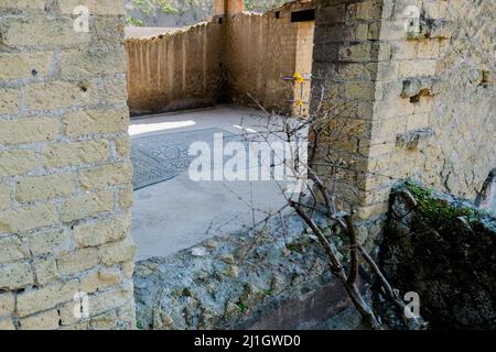 Das Haus des Edelsteins, Juwel des Archäologischen Parks von Herculaneum, berühmt für seine kostbaren Bodenmosaiken das Haus des Edelsteins hat seinen Namen von der Entdeckung eines Edelsteins mit dem Bild von Livia, das fälschlicherweise diesem Haus zugeschrieben wurde, Wenn es tatsächlich aus dem Haus des Granianus stammt, das einst Teil eines einzigen großen Domus war, der das Meer überragt und wahrscheinlich der Familie des Marcus Nonius Balbus gehörte, Und präsentiert im Triclinium eines der schönsten geometrischen Mosaike in Schwarz und Weiß im ganzen Herculaneum Stockfoto