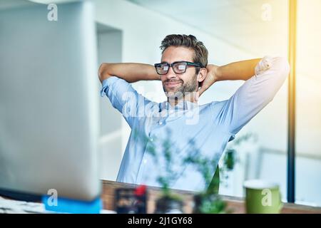 Eine wohlverdiente Pause einlegen. Aufnahme eines jungen Geschäftsmannes, der eine Pause in einem Büro einnahm. Stockfoto