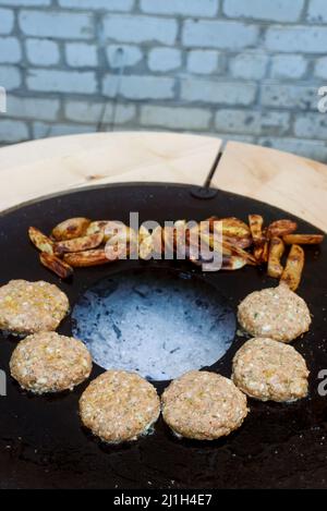 Hähnchenburger Kochen auf einem Grill im Freien. Selektiver Fokus Stockfoto