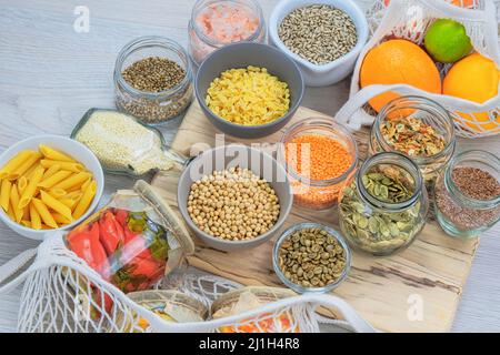 Sortiment vegetarische Bio-Produkte in Gläsern auf weißem Holzhintergrund. Zero Waste Shopping und ein sustanable Lifestyle-Konzept. Draufsicht. Stockfoto