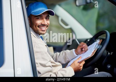 Alle seine Lieferungen laufen reibungslos. Porträt eines glücklichen Lieferers, der seinen Lieferwagen fährt. Stockfoto