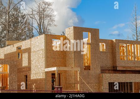 Fragment eines neuen Hauses im Bau in Vancouver, Kanada. Ein neues Haus im Bau und blauer Himmel. Blick auf die Straße, niemand. Stockfoto