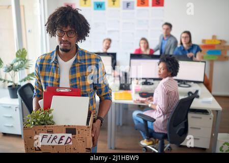 Junge enttäuschte Afro-amerikaner, die aus dem Büro entlassen wurden Stockfoto