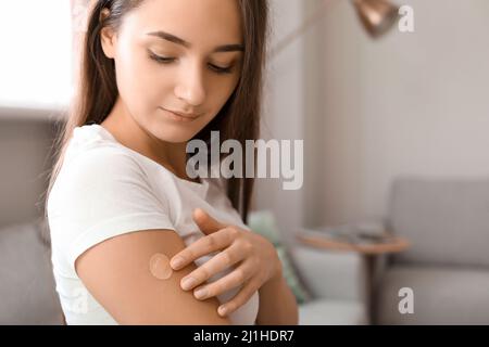 Junge Frau mit aufgetragenen Nikotinpflaster zu Hause. Raucherentwöhnung Stockfoto