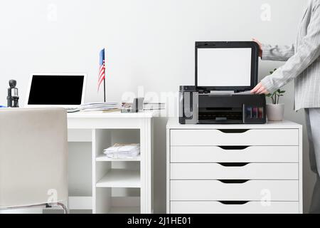 Geschäftsfrau, die das Dokument in einem hellen Büro kopiert Stockfoto