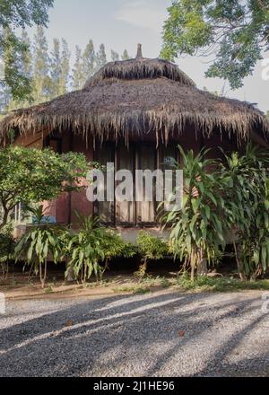 Wunderschöner Blick auf das Sommerhaus aus Holz oder den Sommerbungalow aus Holz, umgeben von einem wunderschönen tropischen Park. Selektiver Fokus. Stockfoto