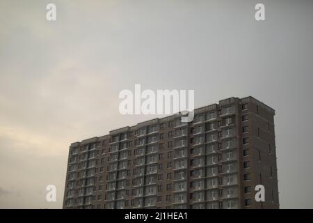 Gegen den Himmel bauen. Bau eines Wohngebäudes. Ein Haus im Rahmen. Einfache Stadtentwicklung im Hintergrund ohne unnötige Details. Stockfoto