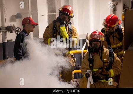 220323-N-TF178-1231 PAZIFISCHER OZEAN (23. März 2022) – Matrosen bekämpfen ein simuliertes Feuer während einer allgemeinen Quartiersübung an Bord des amphibischen Angriffsschiffes USS Makin Island (LHD 8), 23. März. Makin Island führt derzeit Routineoperation in der US 3.-Flotte durch. (USA Navy Foto von Mass Communication Specialist 2. Class Jeremy Laramore) Stockfoto